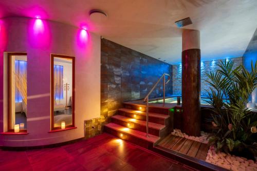 a room with a staircase with purple lights at Hotel La Maison Wellness & Spa in Alleghe