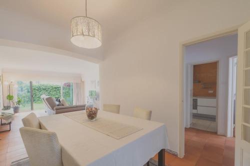 a white dining room with a white table and chairs at The Lisbon Villa with Pool in Lisbon