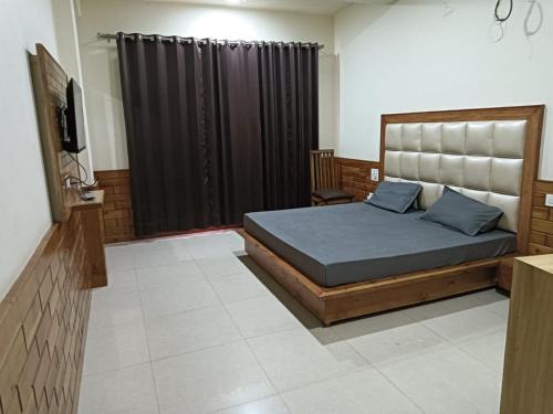 a bedroom with a bed and a black curtain at HOTEL ROSHAN REGENCY By seraj heritage in Shamshi