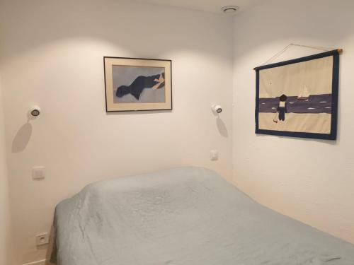 a bedroom with a bed and two pictures on the wall at Appart vue d'exception sur la mer in Bandol