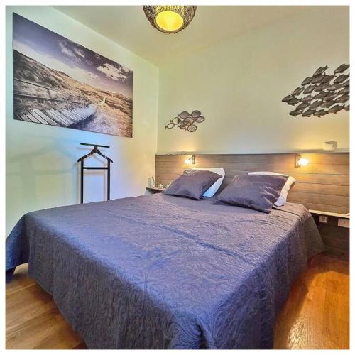 une chambre avec un grand lit avec une couverture bleue dans l'établissement Sous l'oranger des Osages, à Barbentane