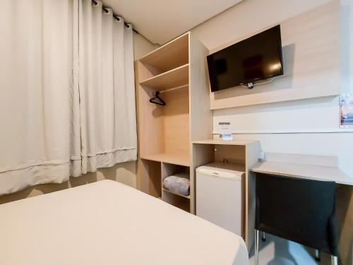 a bedroom with a bed and a desk and a tv at Hotel Itamarati Centro-República in Sao Paulo