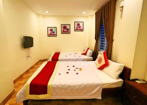 a hotel room with two beds and a tv at Sun Sea Hotel in Quy Nhon