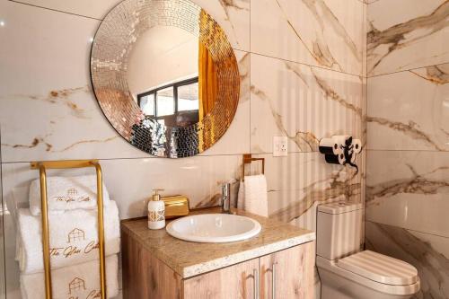 a bathroom with a sink and a mirror at Golden Sunset Room in Sir Lowry Pass
