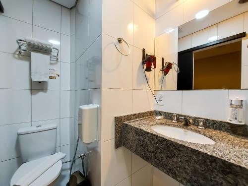 a bathroom with a sink and a toilet and a mirror at Hotel Itamarati Centro-República in Sao Paulo