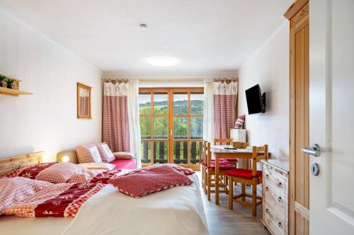 a bedroom with two beds and a desk and a window at Auszeit am Fluss - Donau in Obernzell