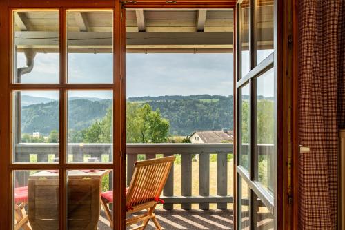 a chair sitting on a balcony with a view of the mountains at Auszeit am Fluss - Donau in Obernzell