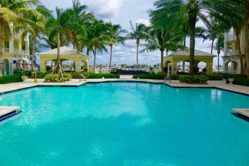 a large blue swimming pool with palm trees at Luxurious, family-friendly 3BR condo on the water in Lantana