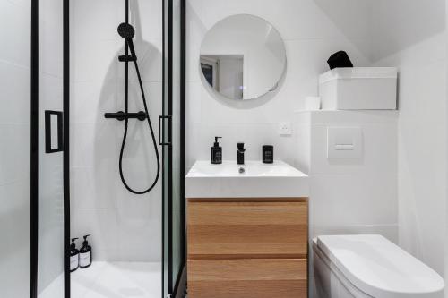 une salle de bain blanche avec une douche et un lavabo dans l'établissement Le mercoeur - Cocon paisible en hyper centre, à Nantes