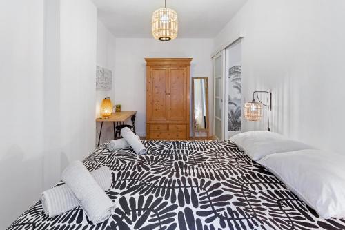 - une chambre blanche avec un lit noir et blanc dans l'établissement Le mercoeur - Cocon paisible en hyper centre, à Nantes