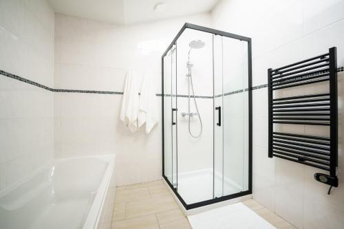 a bathroom with a glass shower and a tub at Le Secret du Château in Beyren-lès-Sierck