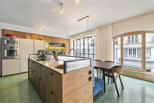 - une cuisine avec un grand îlot et un comptoir dans l'établissement La Grande Ecurie, à Paris