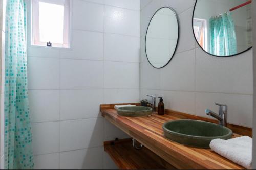 a bathroom with two green sinks and a mirror at Monica’s Apartments in Canning