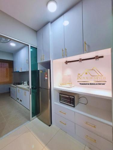 a kitchen with blue cabinets and a stainless steel refrigerator at Royal Homestay Palm Garden in Lahad Datu