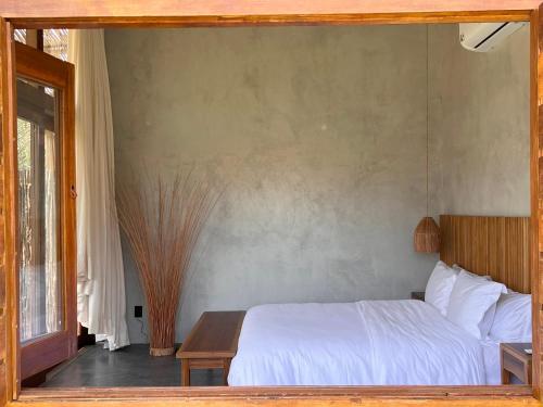 a bedroom with a white bed and a table at 4 Coqueiros GURIU in Guriú