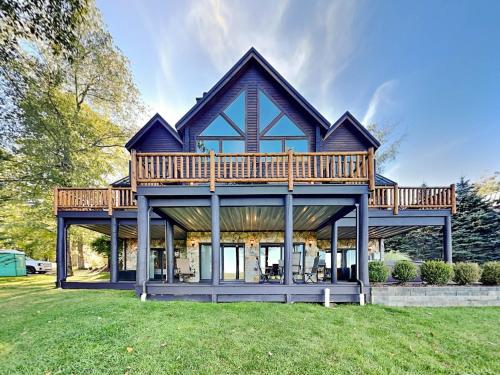 a house with a large deck on top of a yard at Magnificent Mountain Lodge in McHenry