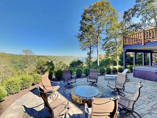 a patio with chairs and a table and a deck at Magnificent Mountain Lodge in McHenry