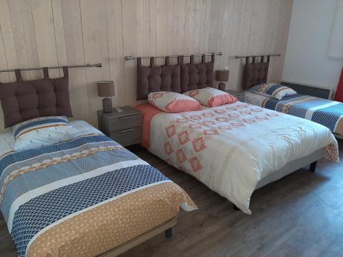 - 2 lits dans une chambre avec 2 jupes de lit dans l'établissement gite petit ecotay, à Saint-Symphorien