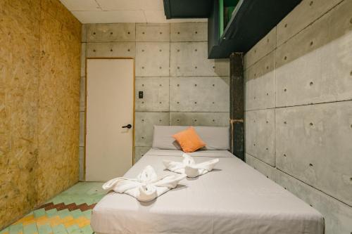 a bedroom with a bed with white towels on it at Eia by Dawata in Cebu City
