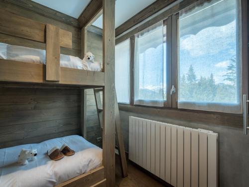 une chambre avec deux lits superposés et une fenêtre dans l'établissement Appartement de charme skis aux pieds à Courchevel 1650 - FR-1-575-133, à Courchevel