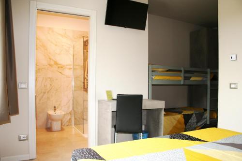 a bedroom with a desk and a bedroom with a bed at Foresteria Diamond in Villa Pedergnano