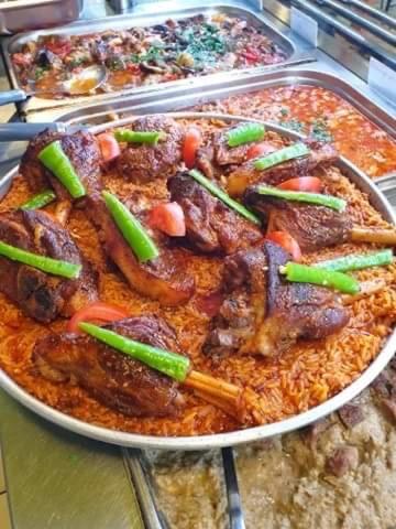 a pizza with meat and vegetables on a table at Népliget Hotel in Budapest