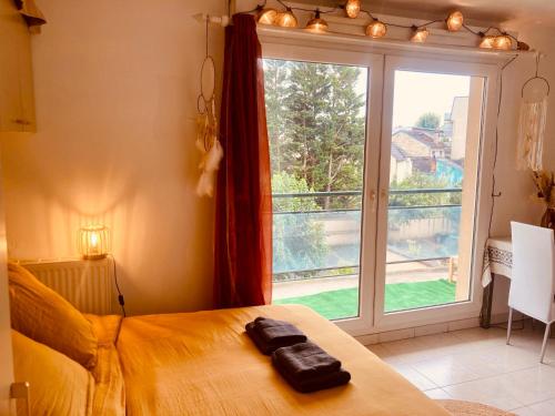 a bedroom with a bed and a large window at Joli studio avec grande terrasse et parking in Vitry-sur-Seine