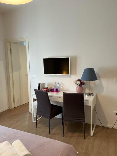 a room with a desk with chairs and a tv at Villa Due Giardini in Padova