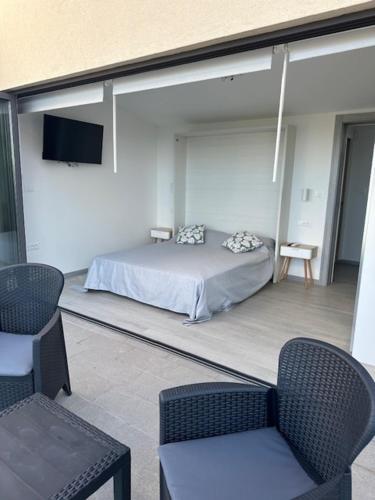 a bedroom with a bed and a tv and chairs at Fragrances of Istria - La Lavanda in Pula