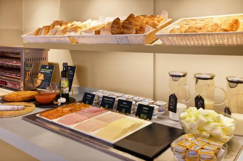 a counter with a bunch of bread and other foods at B&B HOTEL Almería Vicar in Aguadulce