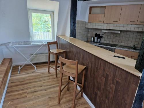 a kitchen with two chairs and a counter top at Wallaby-1-2-Personen in Brunsbüttel