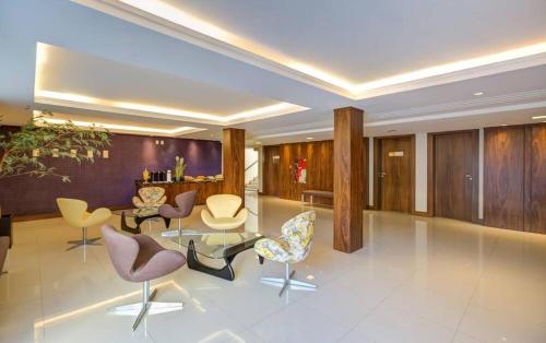 a living room with chairs and a table at GoldMen Business Joinville in Joinville