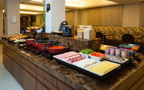 a buffet line with different types of food on a counter at GoldMen Business Joinville in Joinville