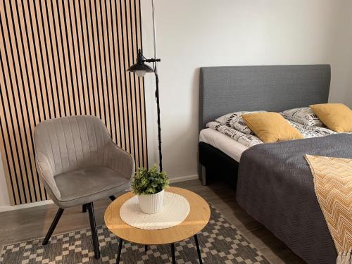 a bedroom with a bed and a chair and a table at Studio apartment B13 in the city center in Oulu