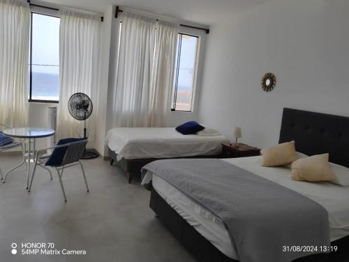 a hotel room with two beds and a table and a chair at Albamar - Casa Antonio - Beach house in El Ñuro