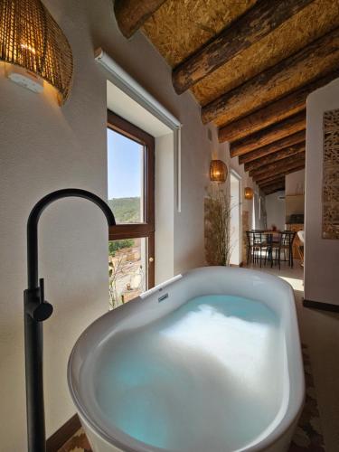 a large bath tub in a bathroom with a window at Apartamentos Rurales LA BUENA ESTRELLA in Alcalá del Júcar