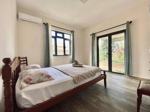 a bedroom with a bed and a large window at 2-Bedroom Apt in Exclusive Gated Residence - BS1 in Flic-en-Flac