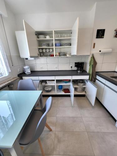a kitchen with white cabinets and a table and chairs at Haus Traudel in Overath
