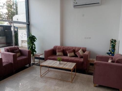 a living room with couches and a coffee table at فندق مناير الاصول in Al Khansāk