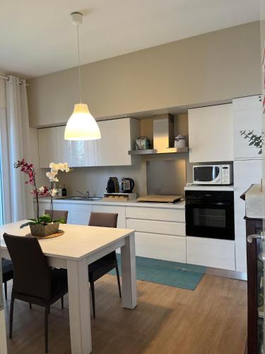 a kitchen with a table and chairs and a kitchen with white cabinets at Villa Due Giardini in Padova
