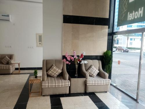 two chairs in a lobby with a vase of flowers at فندق مناير الاصول in Al Khansāk