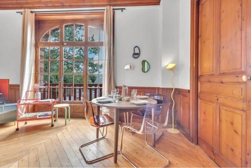 une salle à manger avec une table et des chaises et une fenêtre dans l'établissement L'évasion Colorée, à Houlgate