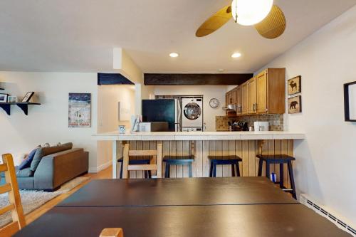 a kitchen and living room with a table and chairs at Mountain Stream Condo in Avon