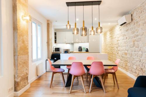 une cuisine et une salle à manger avec une table et des chaises roses dans l'établissement Loft 4 BR Montmartre Pigalle AC by LCC Agency, à Paris