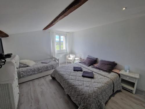 a bedroom with two beds and a couch at Chambres d'hôtes "Les Oliviers" in Saint-Romain-le-Puy