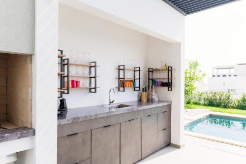 eine Küche mit einem Waschbecken und einem Pool in der Unterkunft Villa Porto Recupera in Kaštela