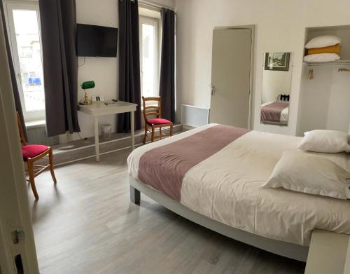 a bedroom with a bed and a table and chairs at Logis Hôtel restaurant des Voyageurs in Saint-Paulien