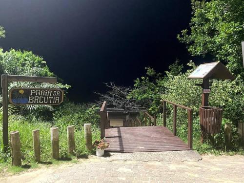 a wooden bridge with a sign in the background at Bacutia, prédio frente ao mar! in Guarapari