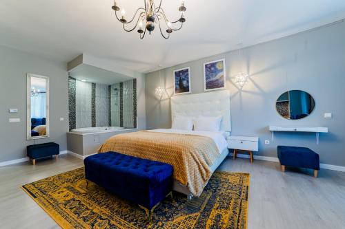 a bedroom with a large bed and a chandelier at Romantic Jacuzzi Luxury Apartment in Sinaia