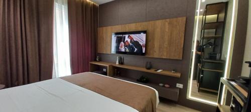 a hotel room with a bed and a television at Galeria's Rooms, Central Tirana, Self Check-In in Tirana